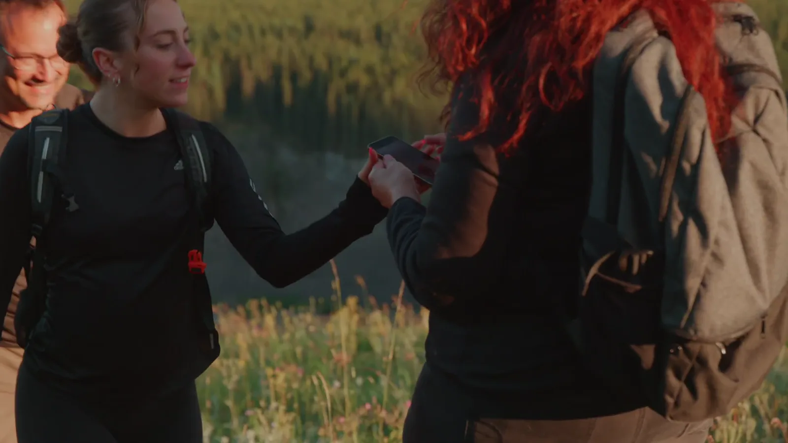 Two hikers pausing together beside a lake