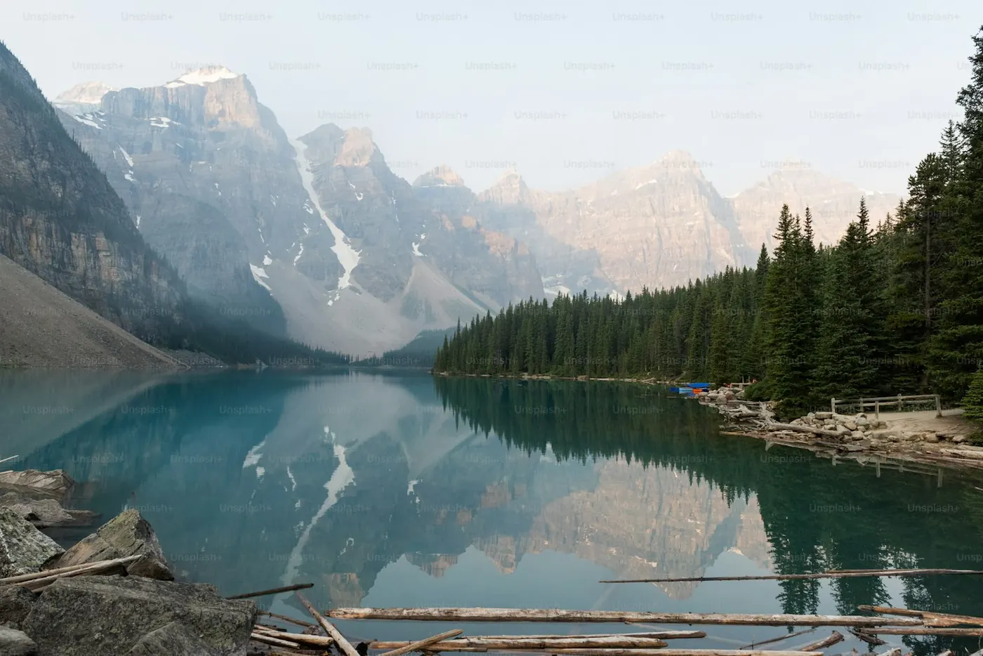 A turquoise mountain lake below a treed ridge